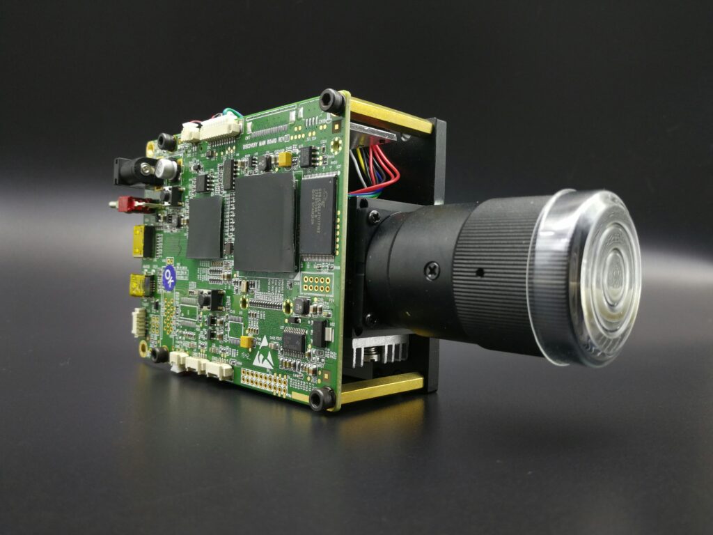 Exposed circuit board and lens of an advanced security camera or surveillance device.
